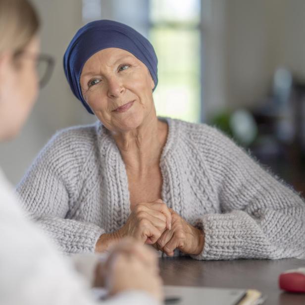 Eine Frau mit Kopftuch sitzt mit einer Ärztin an einem Tisch.