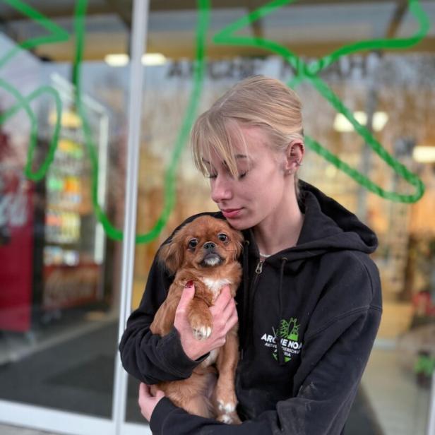 Eine Frau hält einen Welpen im Arm