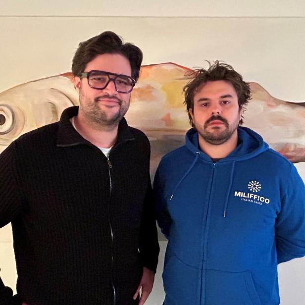 Simon Schubert und Julian Lechner stehen vor einem Fischbild. 