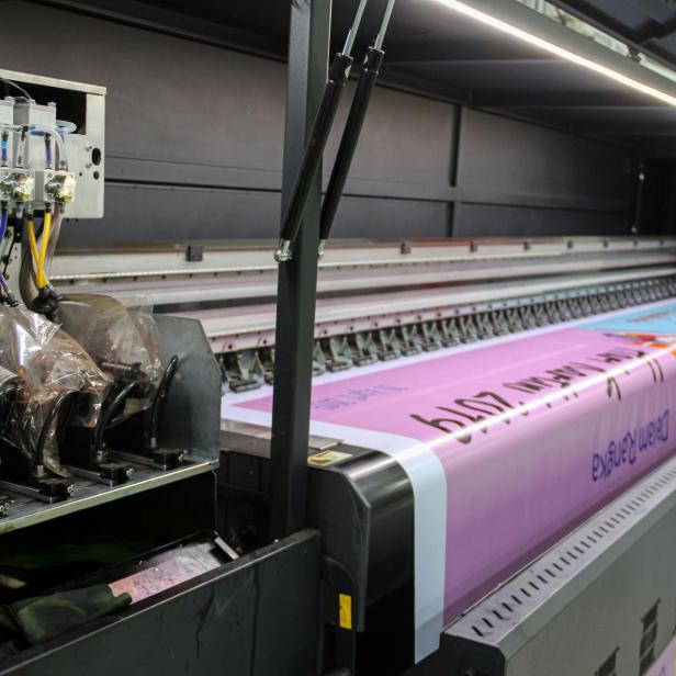 Großformatdrucker bedruckt farbiges Papier mit mehreren Tintenpatronen gleichzeitig.