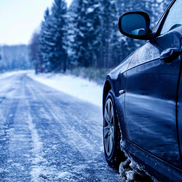 Ein Auto fährt über eine vereiste Straße 