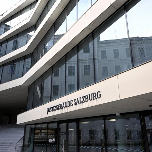 Das Justizgebäude Salzburg mit seiner modernen Glasfassade und dem Schriftzug ist zu sehen.