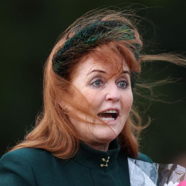 Sarah Ferguson mit Federhut und roten Haaren schaut überrascht.