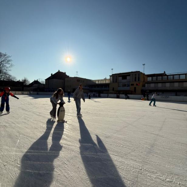 Menschen auf einem Eislaufplatz.