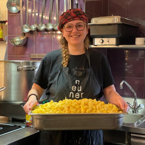 Svenja Knisel mit einem Blech gefüllt mit geschälten Kartoffeln.