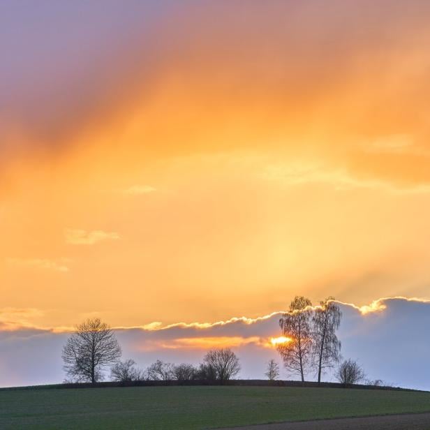 Das Bild zeigt eine ruhige Landschaft, einen orangen Himmel, es vermittelt Stille und Besinnlichkeit.
