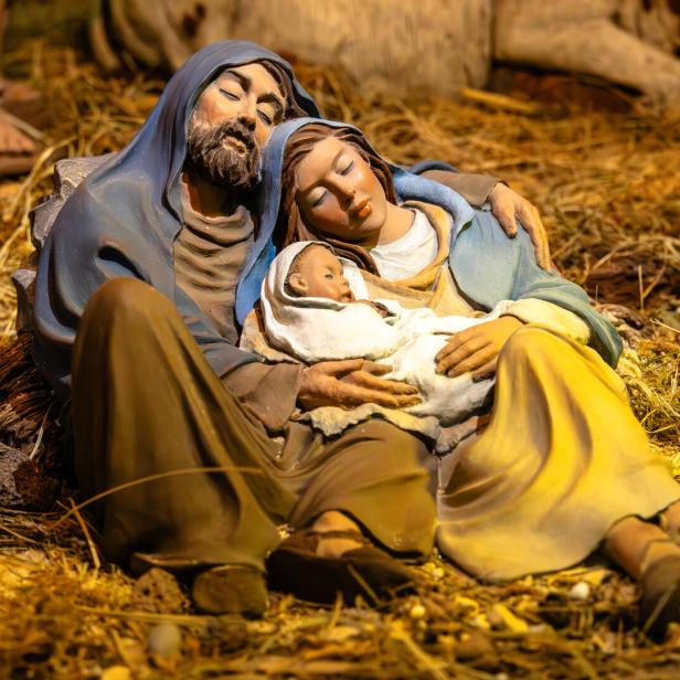 Eine Holzschnitzerei zeigt Josef, Maria und das Jesuskind schlafend im Stall.