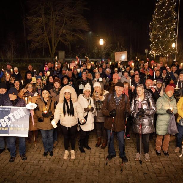 Eine Menschenmenge steht auf einer Wiese.