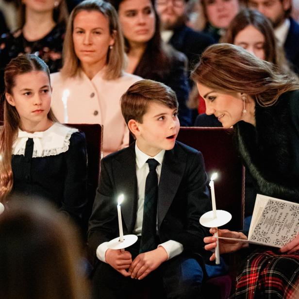 Kate mit Charlotte und Louis bei einer Weihnachtsveranstaltung, alle halten Kerzen.