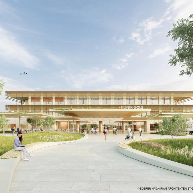 Moderne Klinik mit großer Glasfassade, umgeben von Grünflächen, Menschen sitzen und gehen auf dem Vorplatz, ein Rettungswagen steht rechts.