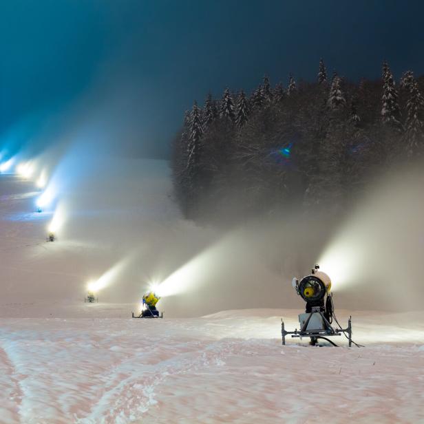 snow cannons working at night in the mountains