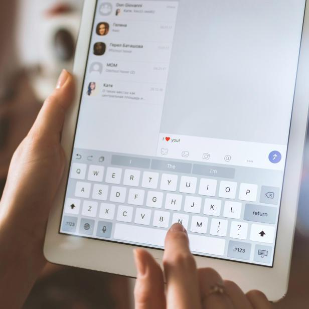 Person schreibt auf einem Tablet auf Englisch die Nachricht "Ich liebe dich"