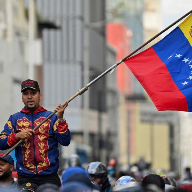ein Mann schwingt eine venezolanische Fahne