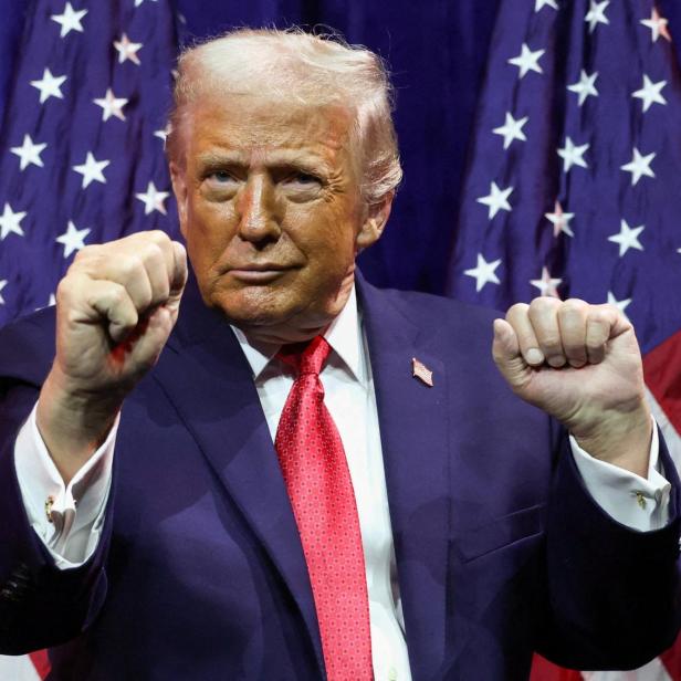 Donald Trump ballt die Fäuste vor US-Flaggen.