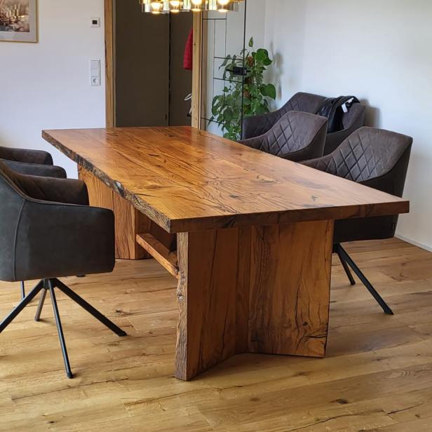 Massiver Esstisch aus Altholz mit vier gepolsterten Stühlen in modernem Esszimmer.