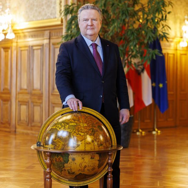 Michael Ludwig im Anzug steht in einem prunkvollen Saal neben einem großen Globus.