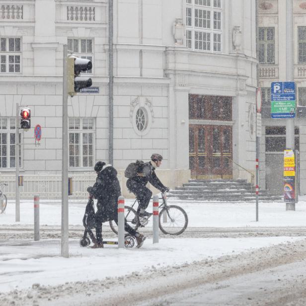 Winter in Wien: Radfahrer an einer verschneiten Kreuzung