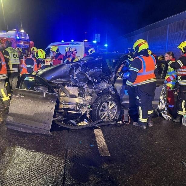 Einsatzkräfte stehen um ein Unfallfahrzeug herum.