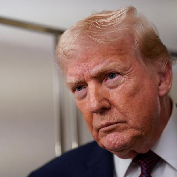 U.S. President Donald Trump looks on as he meets with members of the media aboard Air Force One en route from Florida to Washington