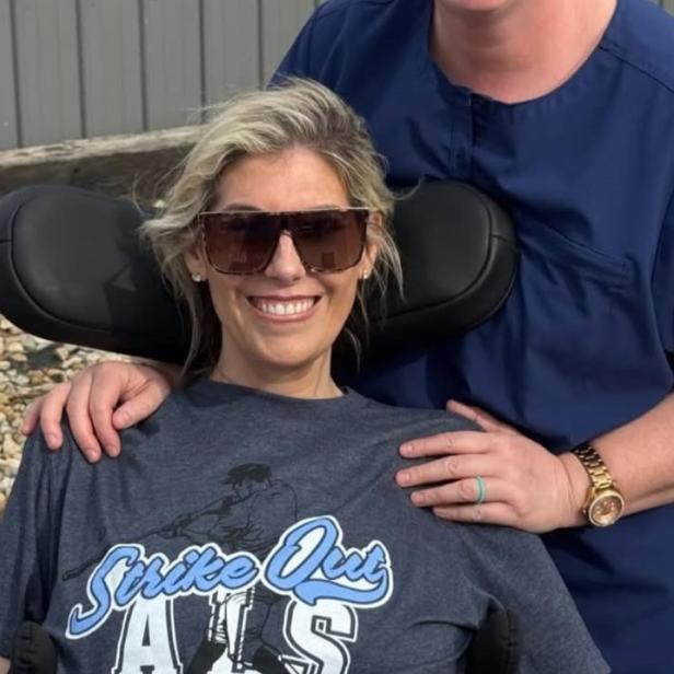 Influencerin Sara Bennett posiert lachend im Rollstuhl für ein Foto