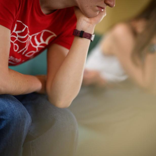 Jugendliche stützen den Kopf auf den Arm.