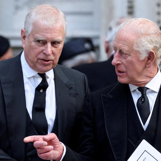 König Charles III. spricht mit Ex-Prinz Andrew, beide in dunklen Anzügen, bei einer Veranstaltung.