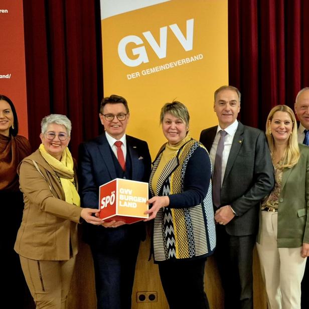 Neun Personen stehen lächelnd nebeneinander, einige halten gemeinsam einen Würfel mit der Aufschrift „GVV BURGENLAND SPÖ“.