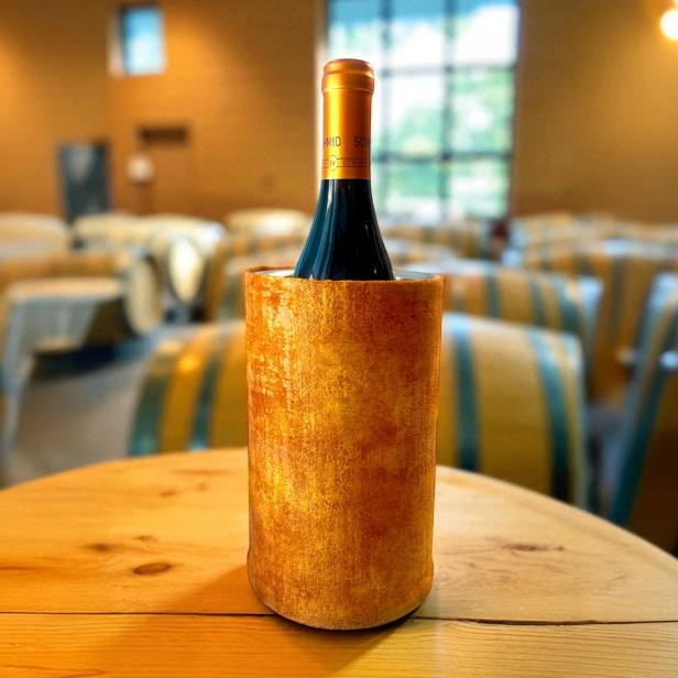 Eine Flasche auf einem Tisch, mit einer Hülle. 