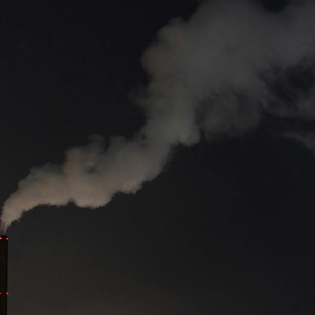 Eine  dichte Rauchschwade vor einem dunklen Nachthimmel.