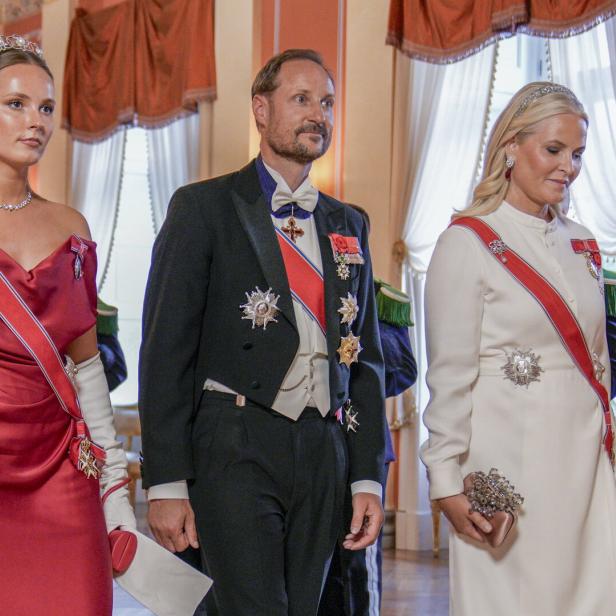 Kronprinz Haakon, Prinzessin Ingrid Alexandra und Kronprinzessin Mette-Marit in festlicher Kleidung bei einem formellen Anlass.
