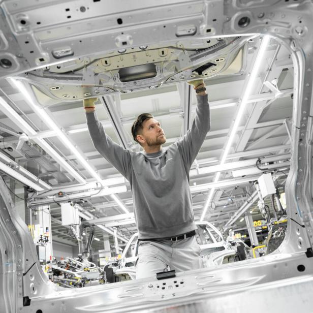 Fabrikarbeiter begutachtet ein Bauteil für den Porsche Cayenne Elektrik in der VW-Fabrik bei Bratislava.