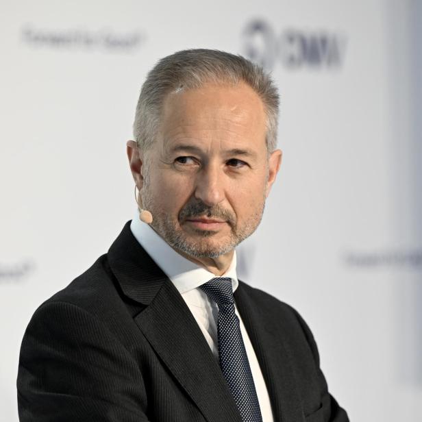 Alfred Stern, OMV-Chef, steht im Anzug mit Mikrofon vor einem Hintergrund mit OMV-Logo und blickt zur Seite.