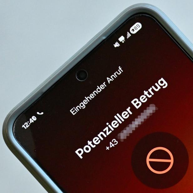 Ein Smartphone zeigt einen eingehenden Anruf mit der Warnung „Potenzieller Betrug“ und einer Telefonnummer an.