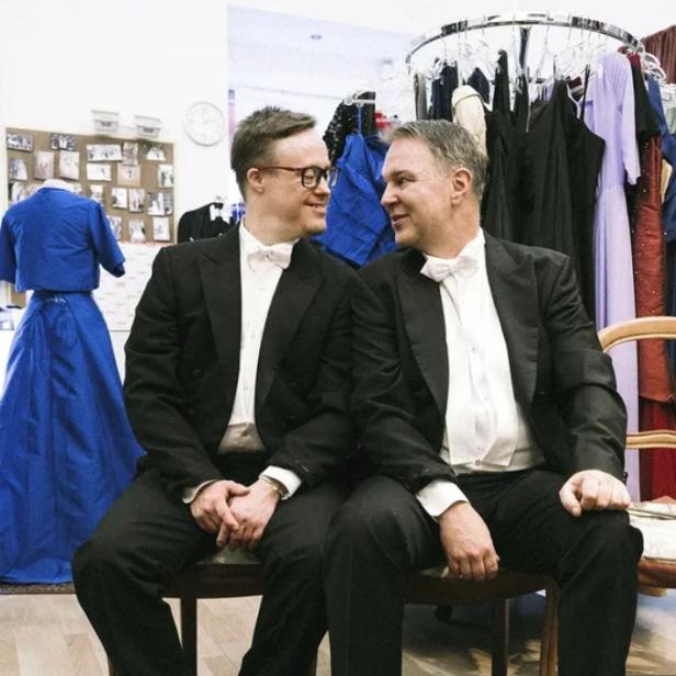 Zwei Herren im Frack sitzen auf einer Bank