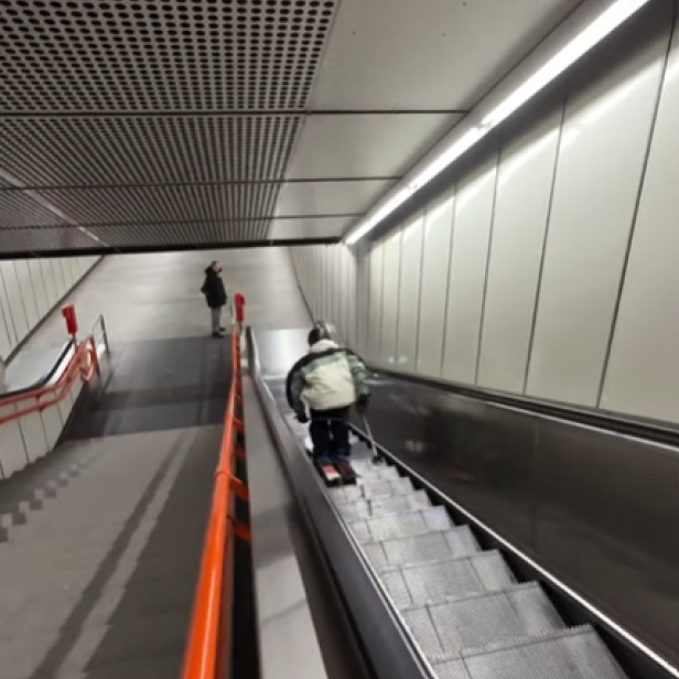 Ein Skifahrer fährt eine Rolltreppe in einer U-Bahn-Station hinunter.