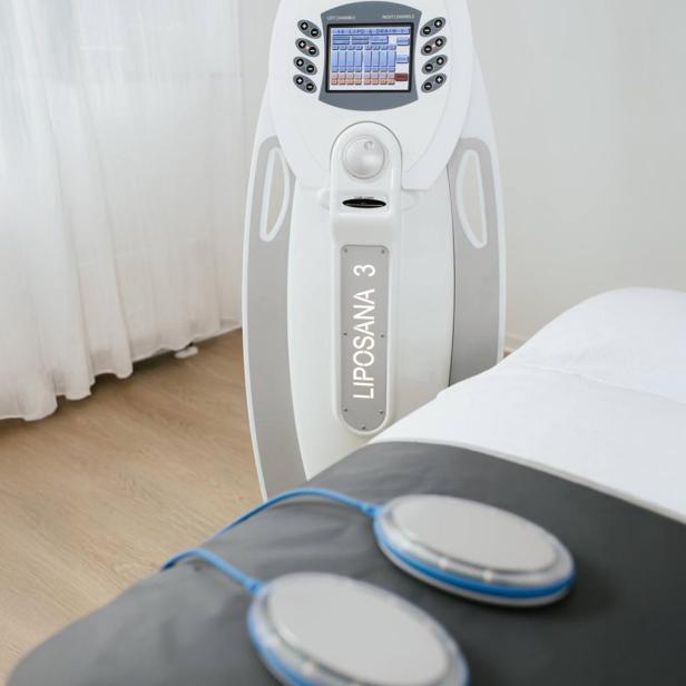 Detox-Gerät LIPOSANA 3 und Behandlungsliege in einem hellen Studio.