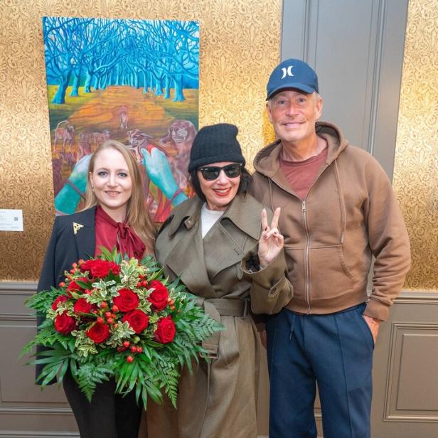 Drei Personen mit Blumenstrauß