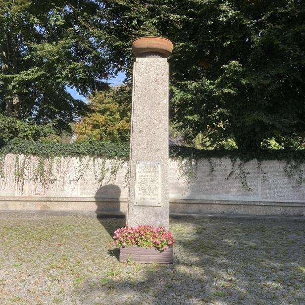 Ein KZ-Mahnmal vor einer Mauer mit Pflanzen