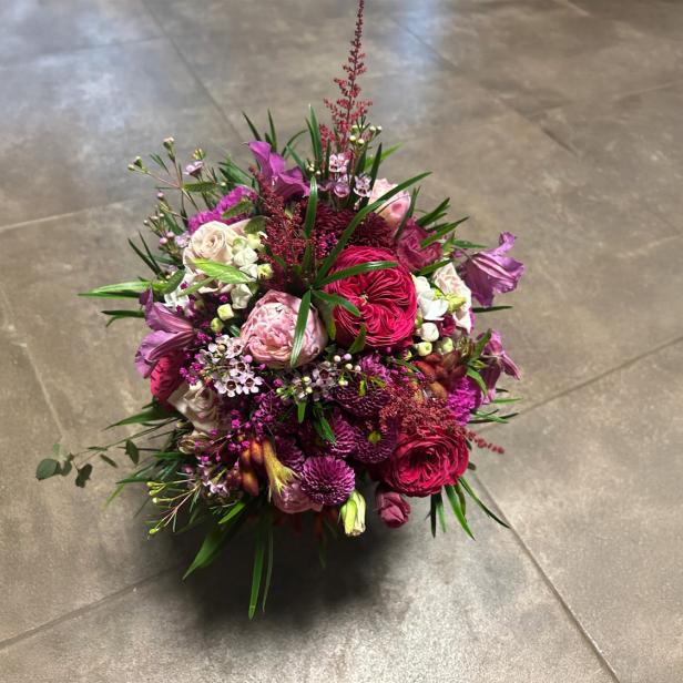 Ein bunter Blumenstrauß steht auf dem Boden. 