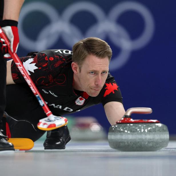 Ein kanadischer Curler lässt einen Curlingstein auf dem Eis gleiten.