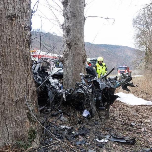 Eine Aufnahme des demolierten Fahrzeugs um einen Baum gewickelt.