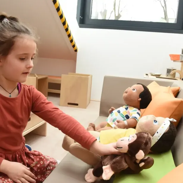 kind spielt mit einem stoffaffen