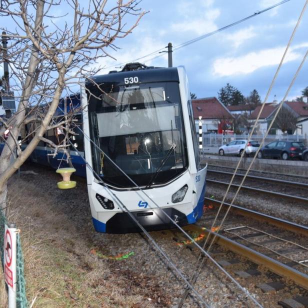 Eine entgleiste Straßenbahn steht schräg auf den Gleisen, umgeben von Oberleitungen und Wohnhäusern im Hintergrund.