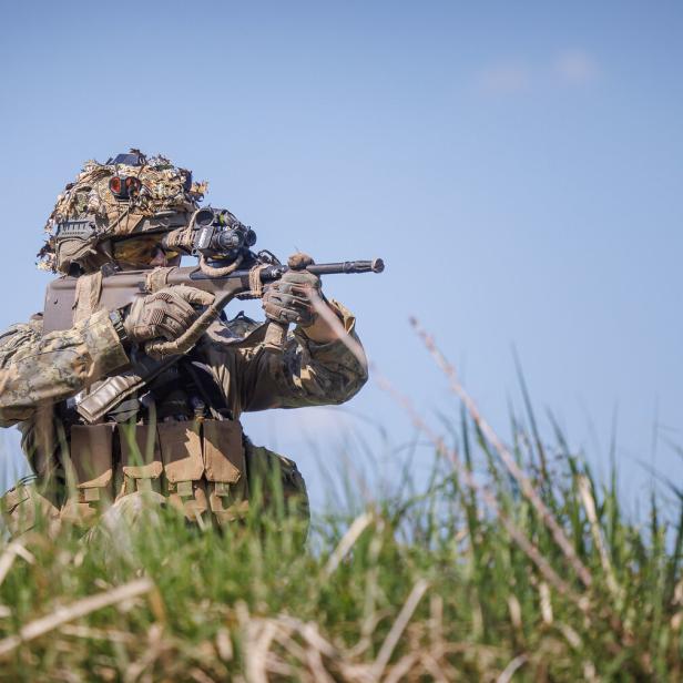 Bundesheersoldat mit Gewehr in einer Wiese