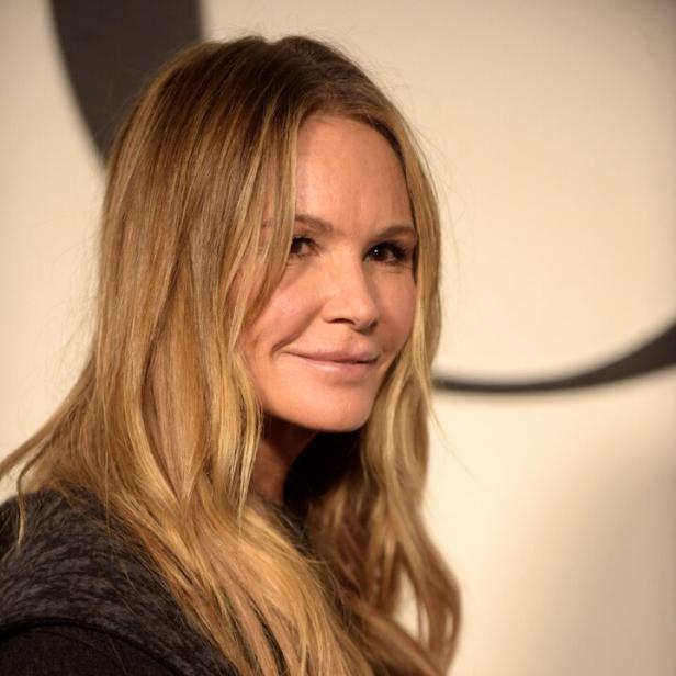 Elle Macpherson mit blonden Haaren und dunkler Jacke lächelt in die Kamera.