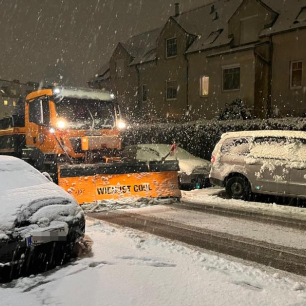 Schneeräumfahrzeug und Autos bei Schneefall