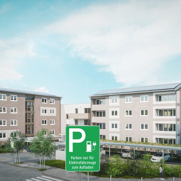 Zwei Gebäude, davor eine Parkplatz-Tafel