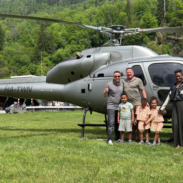 Eine Familie steht vor einem Hubschrauber 