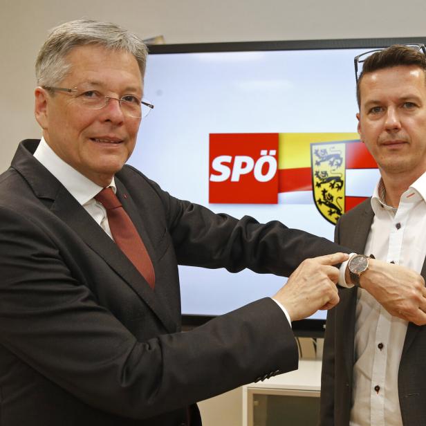 Zwei Männer stehen vor einem Bildschirm mit dem SPÖ-Logo und dem Kärntner Wappen.