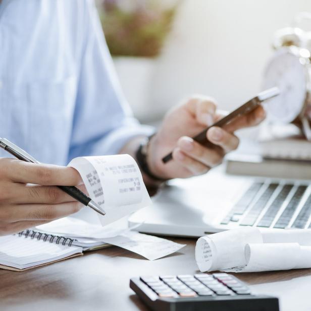 young man holding pen with bills working for calculate business data, taxes, bills payment, Start up counting finance. accounting, statistics, and analytic research concept